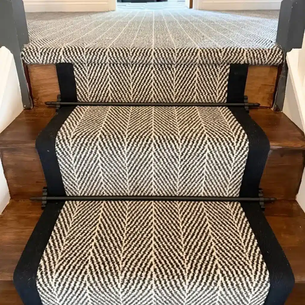 Black & White Patterned Hallway Stair Runner Carpet with Black Carpet Edge Tape on a Dark Wood Staircase fitted by Floormaster Yorkshire